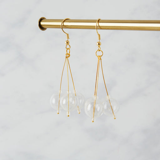 brass earrings with three glass beads in a pendulum