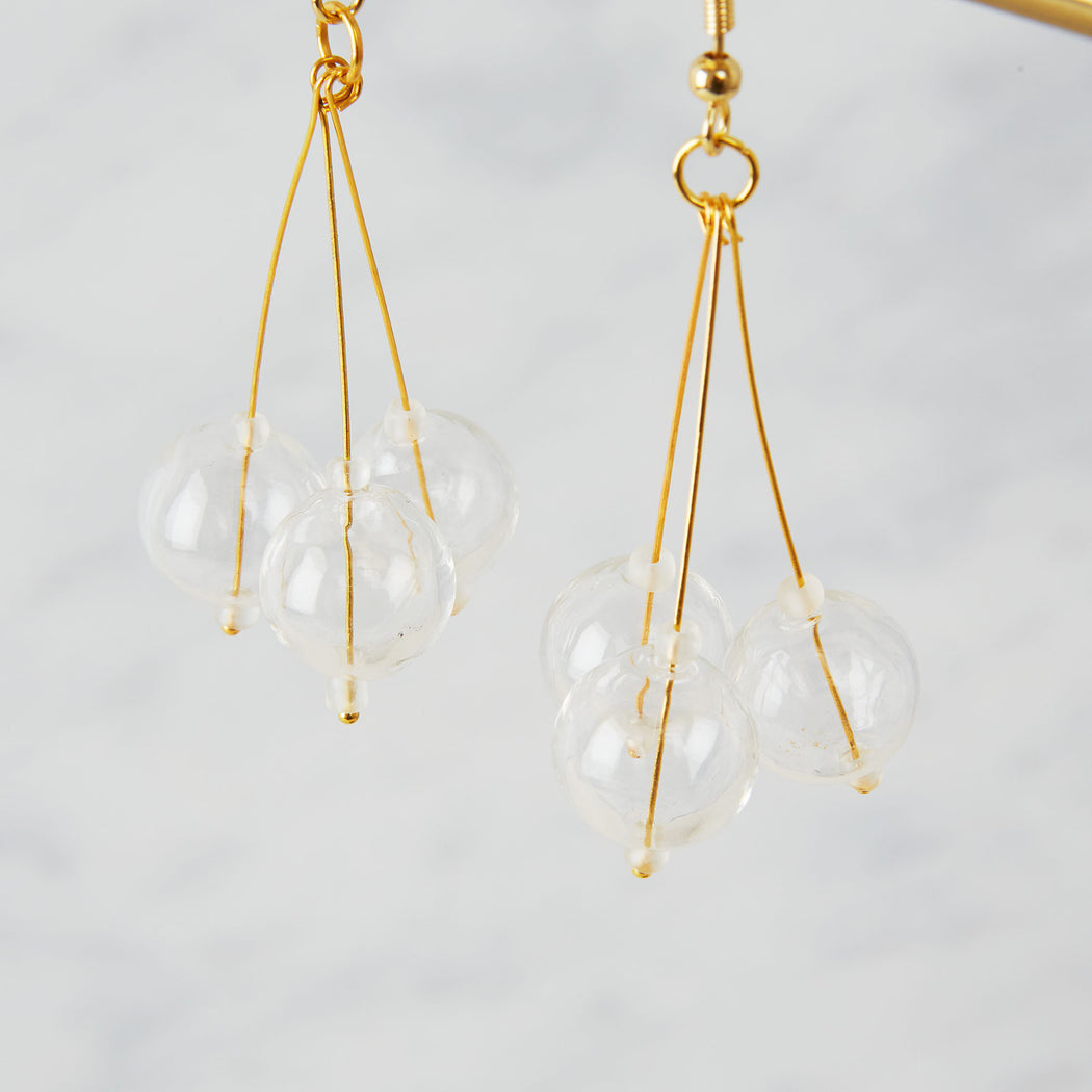 brass earrings with three glass beads in a pendulum